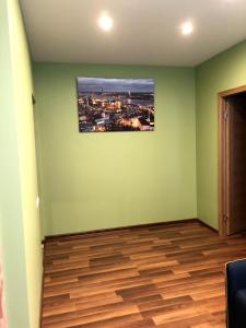 a room with a green wall with a picture of a city at Green and quiet city center in Rīga