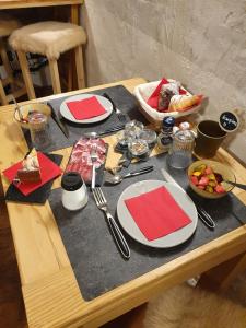 a table with plates and utensils on a table at Maison La Saxe in Courmayeur