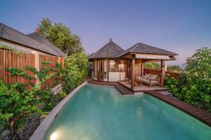 a patio area with a pool and a balcony at Blue Lagoon Avia Villas in Nusa Lembongan