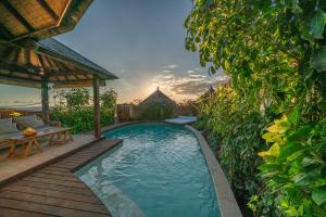 a patio with a pool and a balcony overlooking the water at Blue Lagoon Avia Villas in Nusa Lembongan