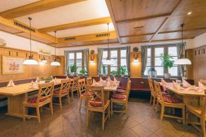 ドナウヴェルトにあるHotel Restaurant Goldener Hirschの木製のテーブルと椅子、窓のあるレストラン