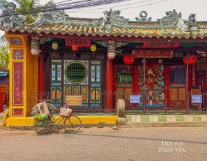 a bike parked in front of a building at B & B Accommodation Service in Hoi An