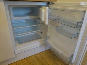 an empty refrigerator with its door open in a kitchen at Garni Sonnleiten in Tirolo