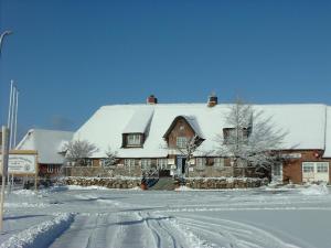 een huis met een met sneeuw bedekt dak bij Haus Dres Ferienwohnung 1 und 2 in Aventoft