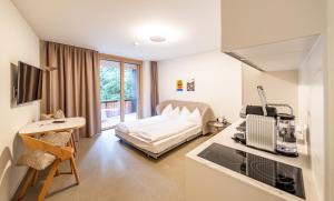 a hotel room with a bed and a kitchen and a living room at The Hide Apartments in Flims