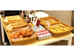 a table with baskets of bread and pastries on it at Kuretake Inn Nagoya Hisayaodori in Nagoya