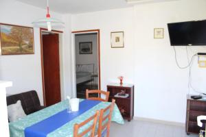 een woonkamer met een blauwe tafel en een televisie bij Apartments DeMori in Primošten