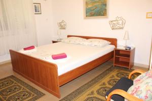 een slaapkamer met een bed met witte lakens bij Apartments DeMori in Primošten