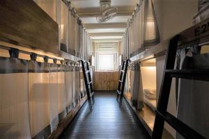 a hallway with a row of bunk beds in a room at 3Howw Hostel @ Sukhumvit 21 in Bangkok