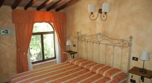 um quarto com uma cama e uma janela em Fattoria di Mugnano em Colle Val D'Elsa