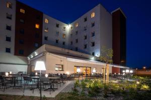 um pátio do hotel com mesas e cadeiras à noite em Ibis Hotel Plzeň em Plzeň