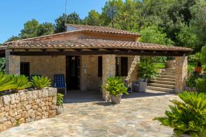 Casa de piedra con porche y pared de piedra en Villa Can Parades By homevillas360, en Pollensa
