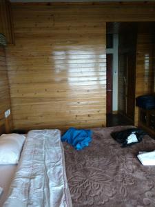 ダージリンにあるHotel Taktsang Darjeelingの木製の壁に大きなベッドが備わるベッドルーム1室