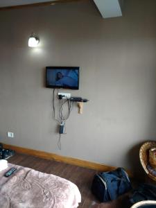 una camera con una parete con una telecamera su un muro di Hotel Taktsang Darjeeling a Darjeeling