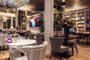 a restaurant with a table and chairs and a bar at Carlton Square Hotel in Haarlem