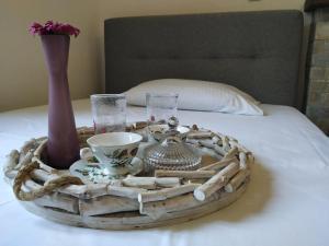 a wooden tray with a tea set on a bed at Lemon Tree and Olive Garden House in Chorto