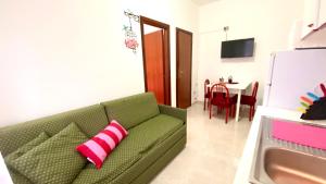 a living room with a green couch with a pink pillow at Belvedere Home in Rodi Garganico
