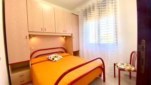 een slaapkamer met een oranje bed en een stoel bij Belvedere Home in Rodi Garganico +46 foto's