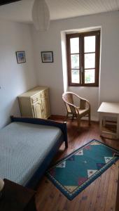 1 dormitorio con 1 cama, 1 silla y 1 mesa en Clèdes, en Clèdes