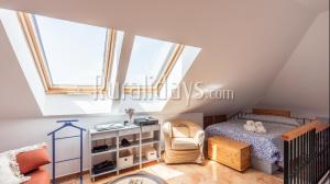a small attic bedroom with a bed and a chair at First line beach apartment in Algarrobo