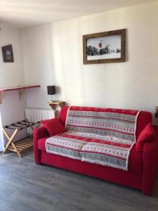 a red couch sitting in a living room at Le Bouquetin - Immeuble Le Pluton in Les Deux Alpes