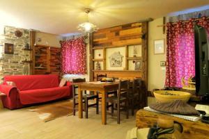 a living room with a red couch and a table at Romantica suite con vasca idromassaggio in Aosta