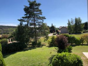 Elle offre une vue sur une cour avec un arbre et une maison. dans l'établissement Le bleu Levant, à Vaux-devant-Damloup