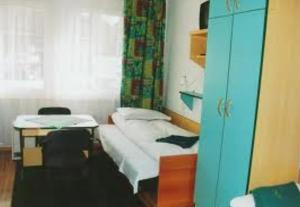 een kleine kamer met een bed en een bureau bij Hotel Janina in Rytro