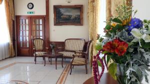 - un salon avec des chaises et un vase de fleurs dans l'établissement Pokoje Gościnne Pałac w Balicach Instytut Zootechniki PIB, à Balice