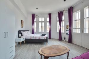 een slaapkamer met paarse gordijnen en een bed en een tafel bij Hostel Musala in Varna