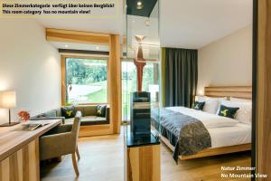 a hotel room with a bed and a desk and a switching their bedroom at Klosterhof – Alpine Hideaway & Spa in Bad Reichenhall