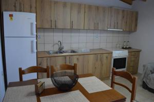 a kitchen with a table and a white refrigerator at Melenia's Sea Front House in Kalamata