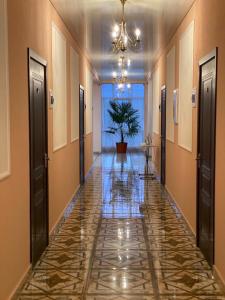 a hallway with a tile floor and a potted plant at SanZazila in Gudauta
