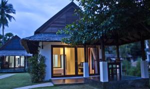 une petite maison avec une porte en verre sur son côté dans l'établissement Nana Beach Hotel & Resort, à Pathiu