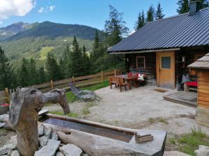 Ampferkaralm Hütte في فورستاو: كابينة خشب مع طاولة نزهة في الحديقة الخلفية