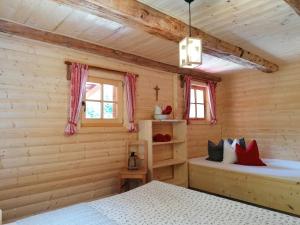 sypialnia z dwoma łóżkami w drewnianej chacie w obiekcie Ampferkaralm Hütte w mieście Forstau
