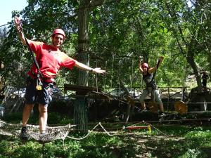 dos hombres parados en una tirolesa en los árboles en Agriturismo San Cataldo, en Motta Camastra