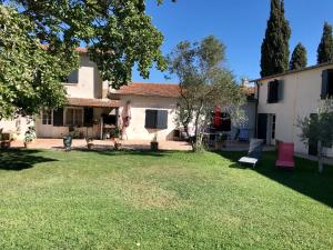 a backyard of a house with a lawn at Mas Du Pont De Laute in Le Cailar
