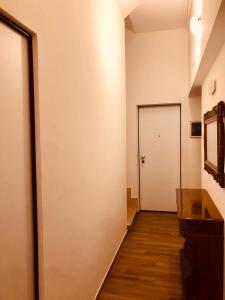 a hallway with a white door and a wooden floor at LeonessHouse in Leonessa