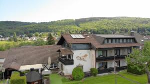 una vista aérea de una casa con montañas en el fondo en Hotel & Restaurant Zum Deutschen Haus en Glashütten