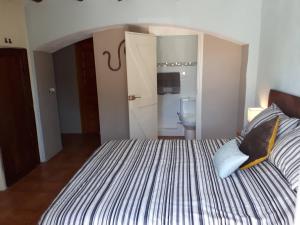 a bedroom with a large bed and a bathroom at Casa de Bello in Tortosa