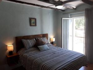 ein Schlafzimmer mit einem Bett mit zwei Lampen und einem Fenster in der Unterkunft Casa de Bello in Tortosa