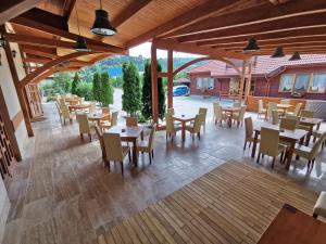 a restaurant with wooden tables and chairs and a patio at Rákóczi Center in Odorheiu Secuiesc