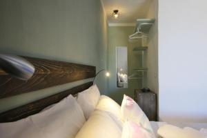 um quarto com uma cama com almofadas brancas em BnB Anacleto em Bassacutena