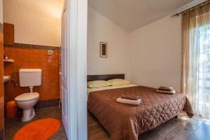 Apartment Maja 1512 في كرينكا: غرفة نوم بسرير وحمام مع مرحاض