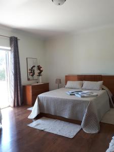 a bedroom with a large bed and a wooden floor at Granja MG in Bombarral