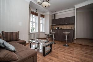 a living room with a couch and a table at Lāčplēša Central Apartments in Riga