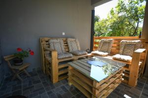 eine Veranda mit einem Sofa, einem Tisch und einem Fenster in der Unterkunft Seoska kuca Stojanović in Kladovo