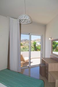 a bedroom with a bed and a large glass window at Giorgos and Maria in Plakias