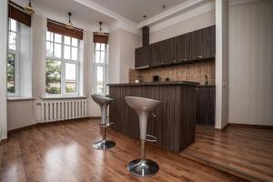 a kitchen with a counter and stools in a room at Lāčplēša Central Apartments in Riga